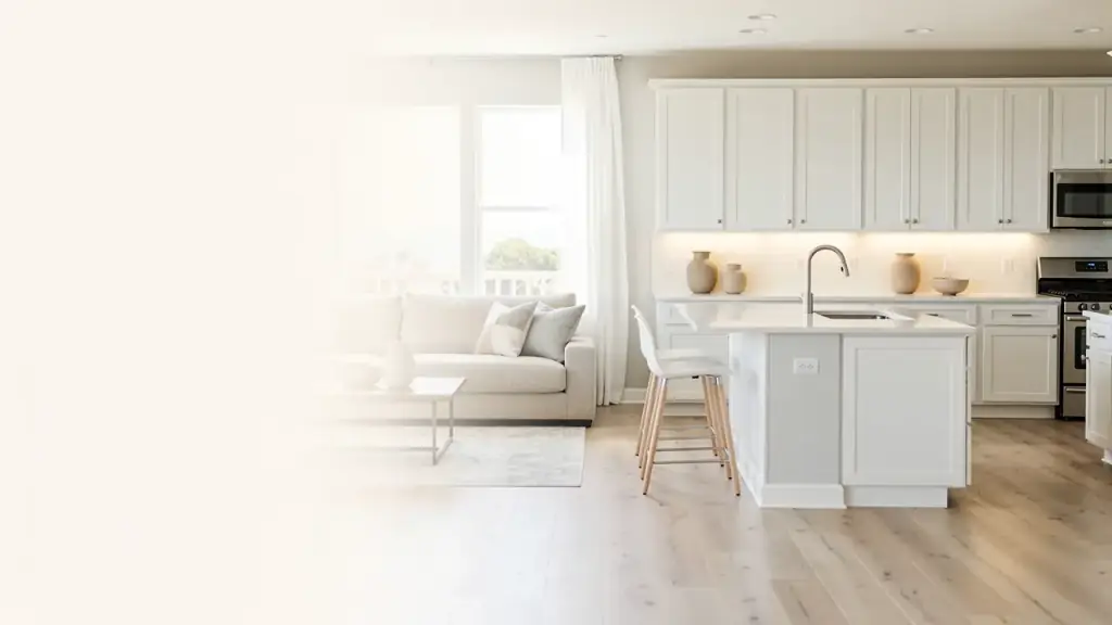 Open-plan kitchen and living room with a white quartz island, white cabinets and pale oak floors